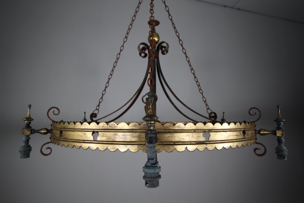 A 19th-century Gothic Revival brass and iron chandelier featuring a scalloped coronet band supported by suspension chains and curved lower scrollwork. View IX