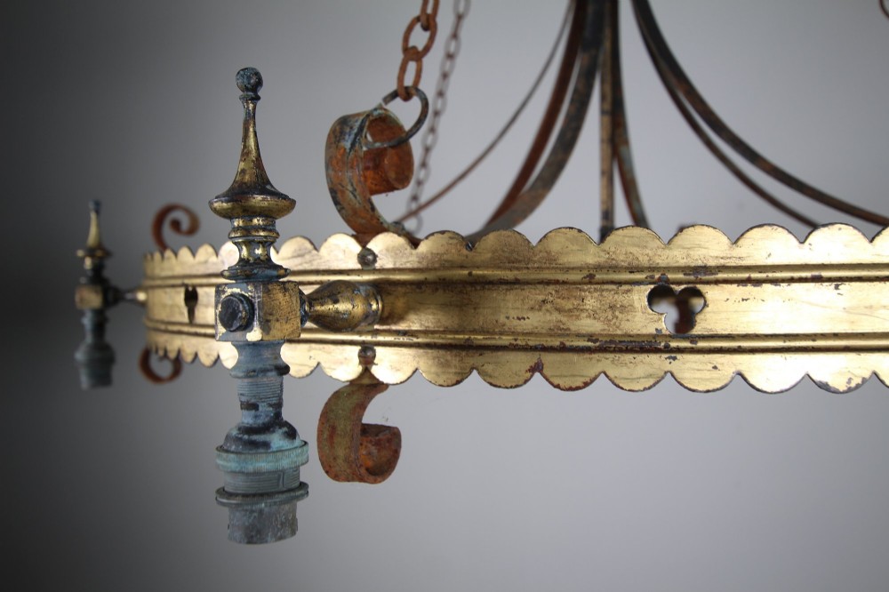 A 19th-century Gothic Revival brass and iron chandelier featuring a scalloped coronet band supported by suspension chains and curved lower scrollwork. View X