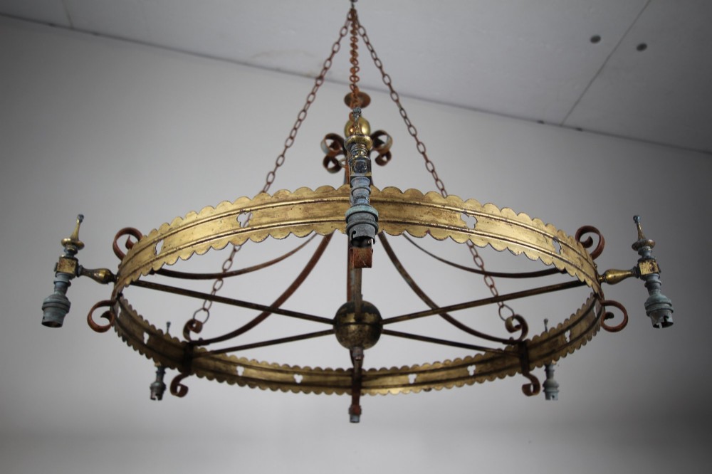 A 19th-century Gothic Revival brass and iron chandelier featuring a scalloped coronet band supported by suspension chains and curved lower scrollwork. View XI