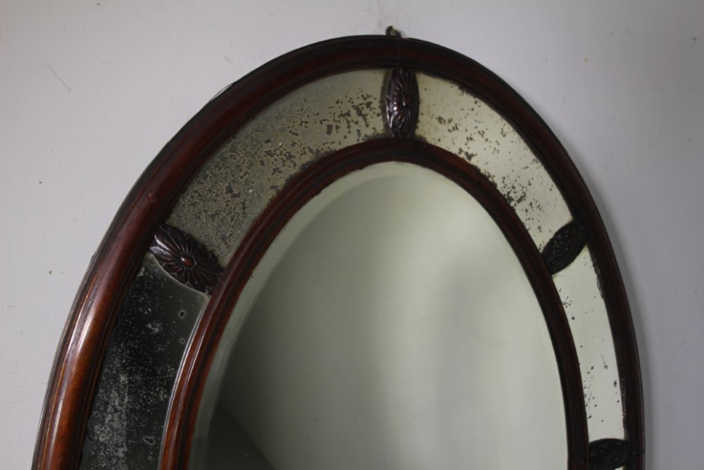A large 19th-century oval mahogany wall mirror featuring a double-banded wooden frame with segmented antiqued glass borders. View IV