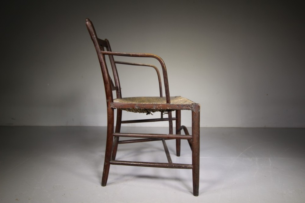 A dark brown painted Georgian Yealmpton armchair featuring a woven rush seat and an X-frame back splat. View III
