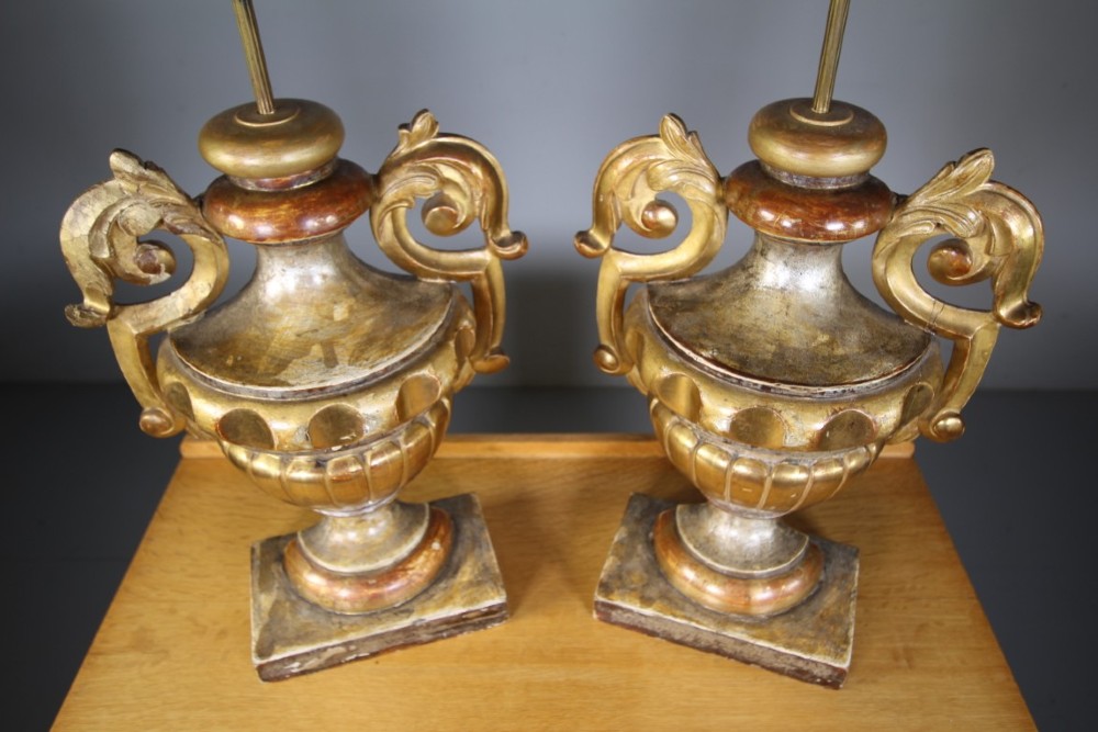 A pair of 19th-century carved pine urn table lamps with distressed gold leaf finish, scrolled handles, and square plinth bases. View II