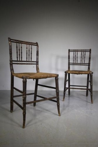A pair of antique Regency dark painted pine side chairs featuring faux bamboo turned frames and woven rush seats. View V