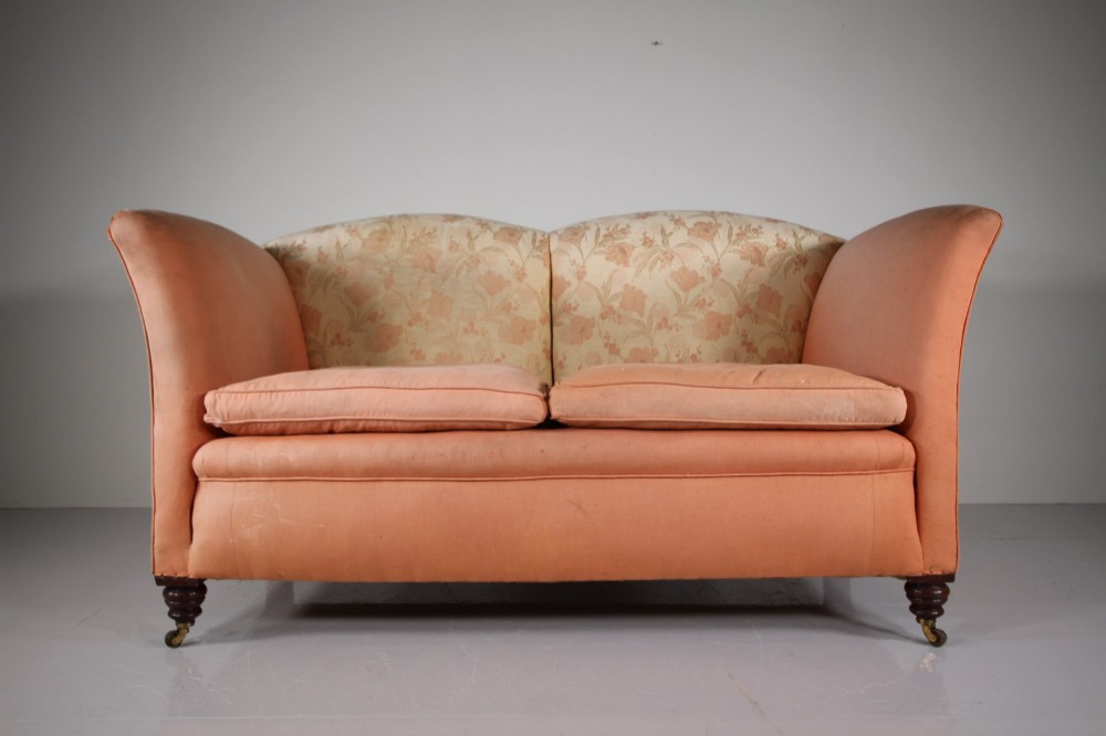 A nineteenth-century two-seat sofa upholstered in peach-coloured fabric with a floral damask inner back panel, supported by turned mahogany legs on brass castors. View III