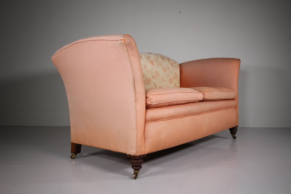 A nineteenth-century two-seat sofa upholstered in peach-coloured fabric with a floral damask inner back panel, supported by turned mahogany legs on brass castors. View IV