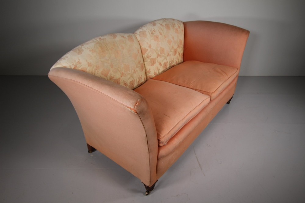 A nineteenth-century two-seat sofa upholstered in peach-coloured fabric with a floral damask inner back panel, supported by turned mahogany legs on brass castors. View VI