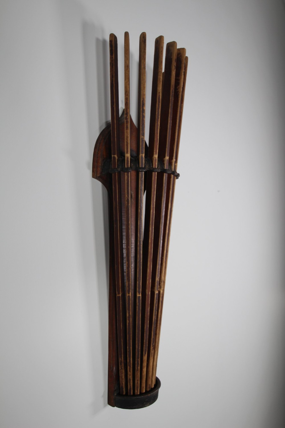 An antique wall-mounted wooden clothes dryer featuring multiple moveable laths fanning out from a central dark wood backplate. View VI