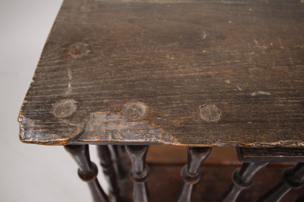 A 17th-century dark oak wall-mounted livery cupboard featuring a rectangular frame enclosing closely set turned wooden spindles on all open sides. View II