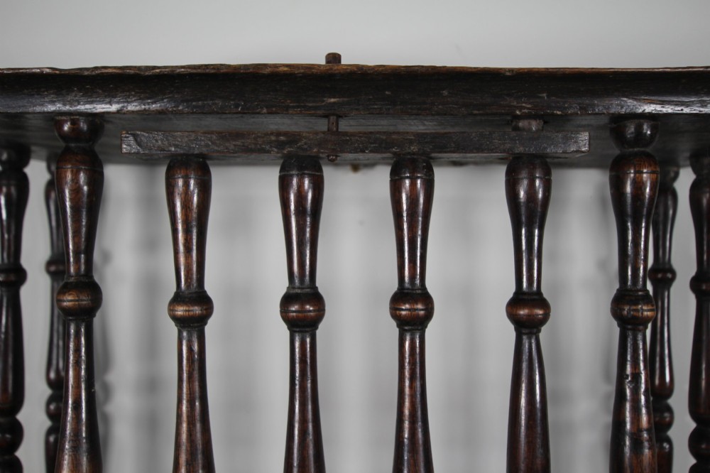 A 17th-century dark oak wall-mounted livery cupboard featuring a rectangular frame enclosing closely set turned wooden spindles on all open sides. View VI