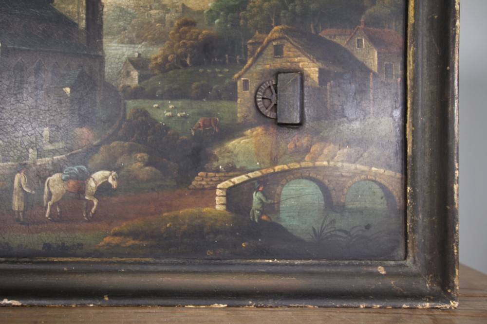 An 18th-century oil painting on tin depicting a church landscape with integrated mechanical clock hands and a visible waterwheel mechanism, enclosed in a dark wooden frame. View V