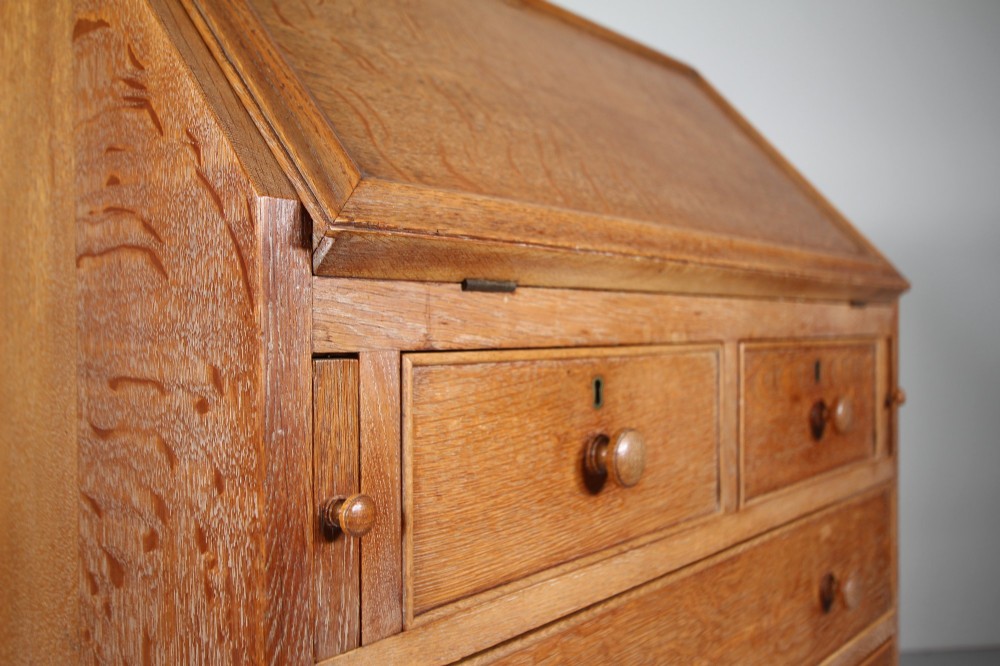 A 1920s oak writing bureau featuring a sloped fall-front desk above four drawers with turned wooden knobs, set on spherical bun feet. View II