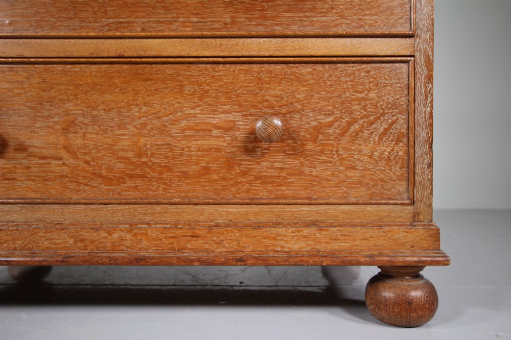 A 1920s oak writing bureau featuring a sloped fall-front desk above four drawers with turned wooden knobs, set on spherical bun feet. View IV