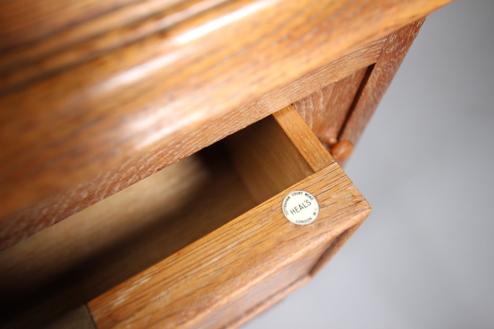 A 1920s oak writing bureau featuring a sloped fall-front desk above four drawers with turned wooden knobs, set on spherical bun feet. View VI