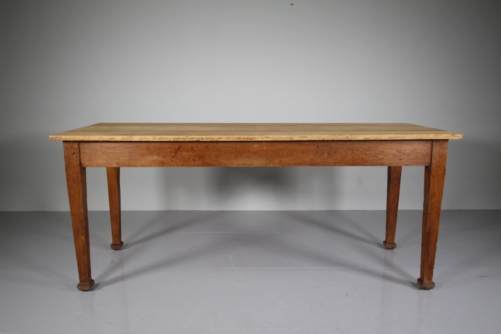 An English Edwardian antique oak dining table featuring a rectangular plank top and four square tapered legs. View III