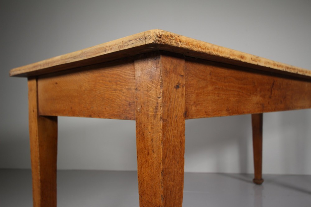 An English Edwardian antique oak dining table featuring a rectangular plank top and four square tapered legs. View V