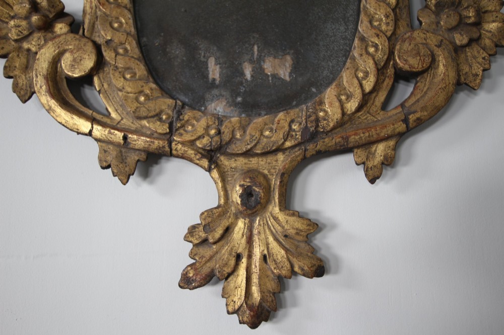 An 18th-century carved wood and gilt wall mirror featuring an ornate cartouche frame with acanthus leaf scrolls, rope twist trim, and a foxed mirror plate. View II