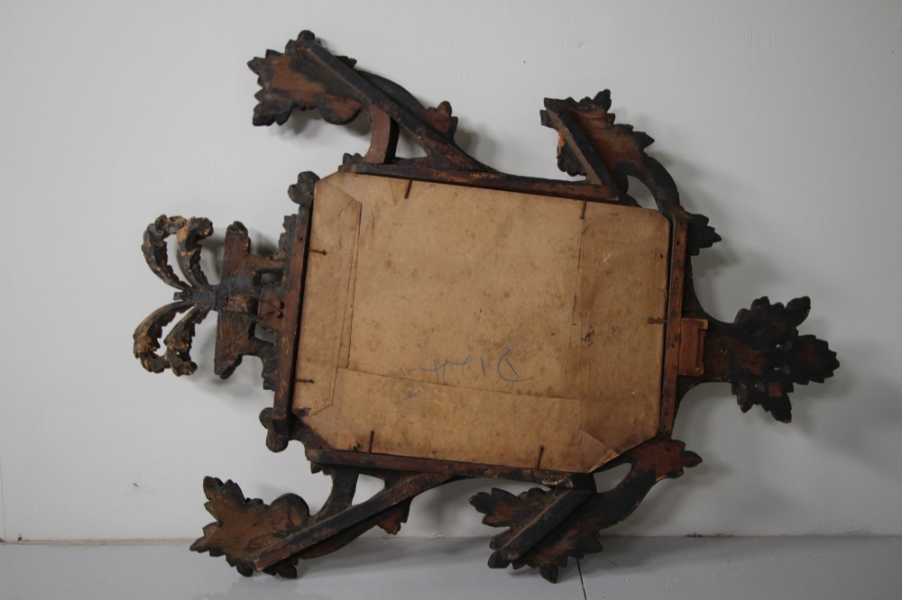 An 18th-century carved wood and gilt wall mirror featuring an ornate cartouche frame with acanthus leaf scrolls, rope twist trim, and a foxed mirror plate. View IV