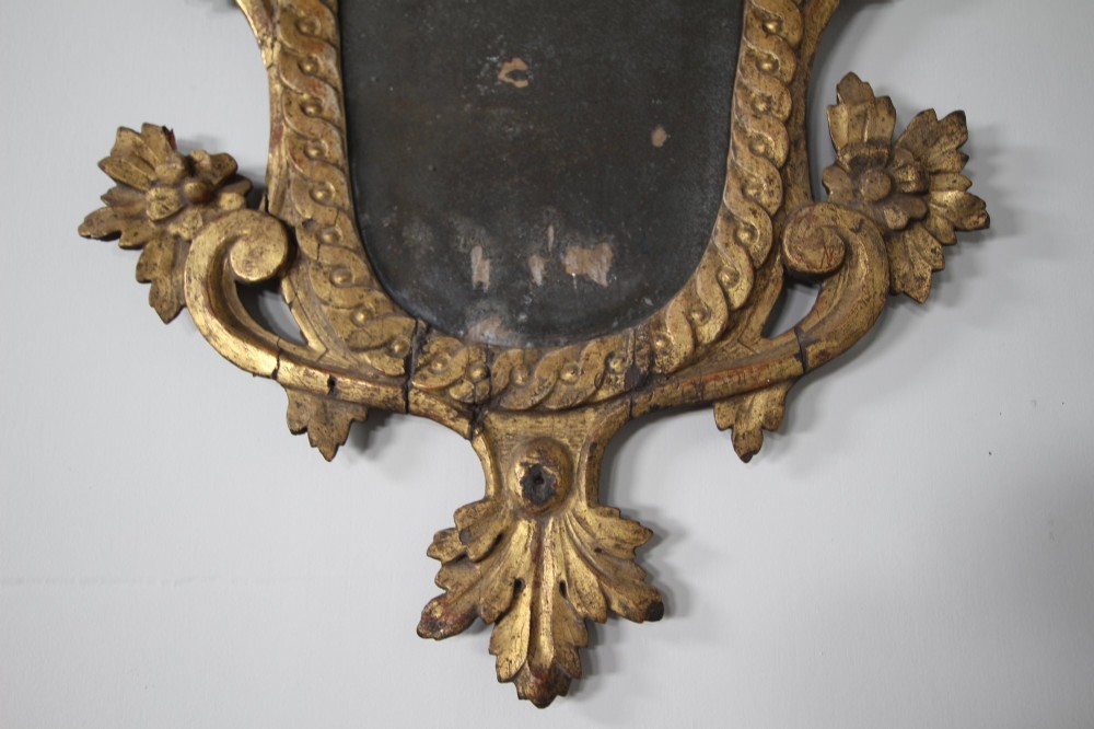 An 18th-century carved wood and gilt wall mirror featuring an ornate cartouche frame with acanthus leaf scrolls, rope twist trim, and a foxed mirror plate. View VIII