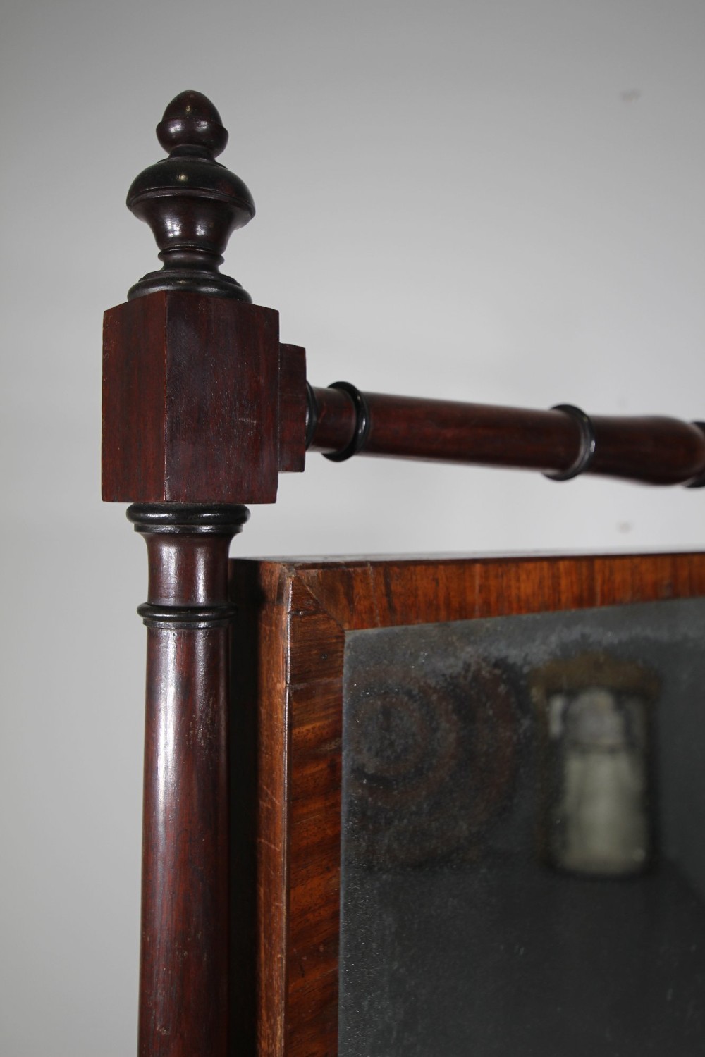 An English Regency mahogany cheval mirror featuring a rectangular tilting glass plate supported by turned uprights and splayed legs with brass paw castors. View III
