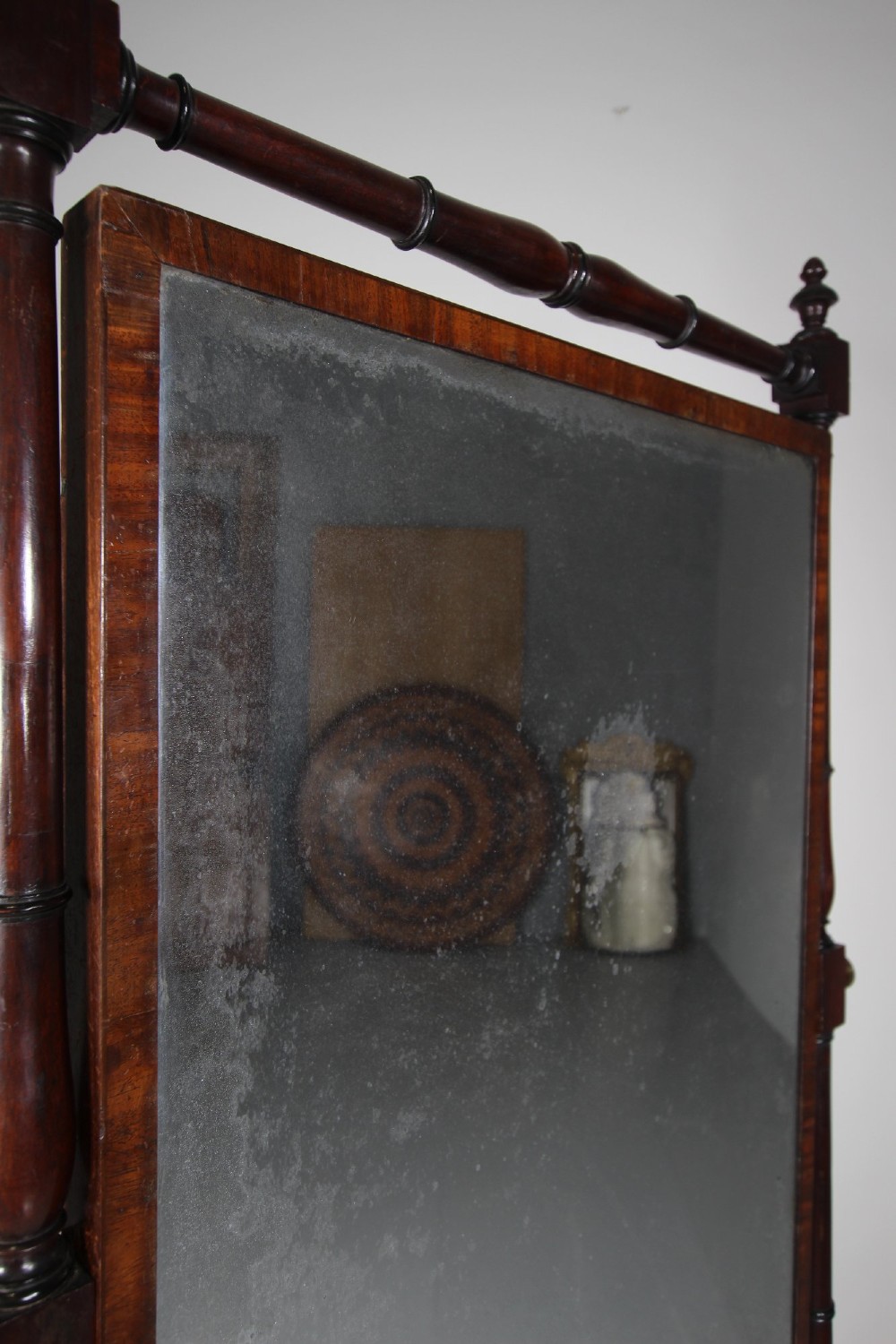 An English Regency mahogany cheval mirror featuring a rectangular tilting glass plate supported by turned uprights and splayed legs with brass paw castors. View IV