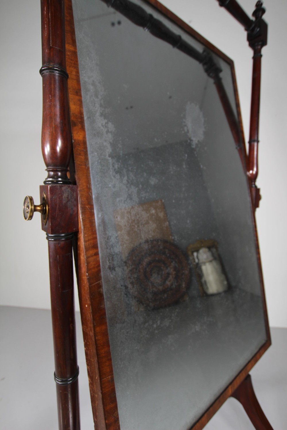 An English Regency mahogany cheval mirror featuring a rectangular tilting glass plate supported by turned uprights and splayed legs with brass paw castors. View VIII