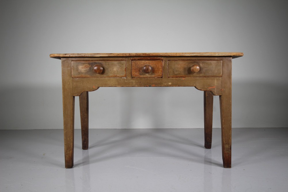An 18th-century English painted pine serving table featuring three drawers with wooden handles, a shaped apron, and tapered square legs. View III
