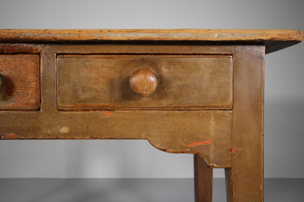 An 18th-century English painted pine serving table featuring three drawers with wooden handles, a shaped apron, and tapered square legs. View IV