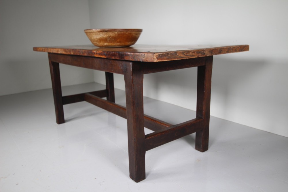 An 18th-century rustic fruitwood dining table featuring a solid plank top and straight square legs joined by a low stretcher base. View II