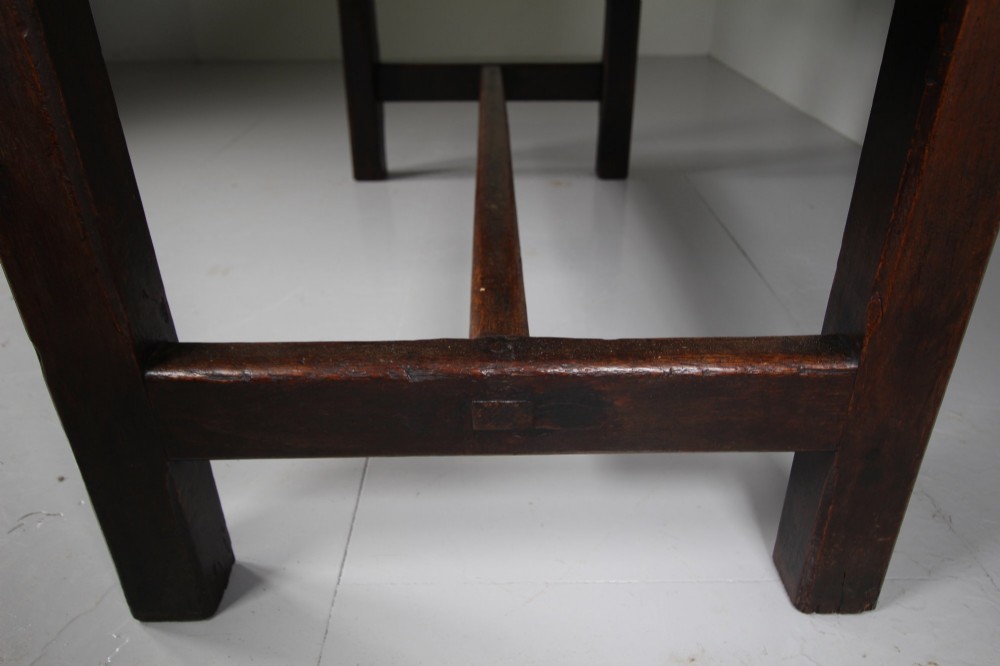 An 18th-century rustic fruitwood dining table featuring a solid plank top and straight square legs joined by a low stretcher base. View III