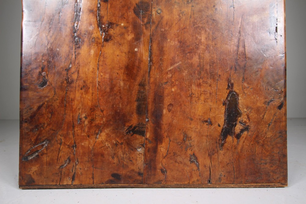 An 18th-century rustic fruitwood dining table featuring a solid plank top and straight square legs joined by a low stretcher base. View V