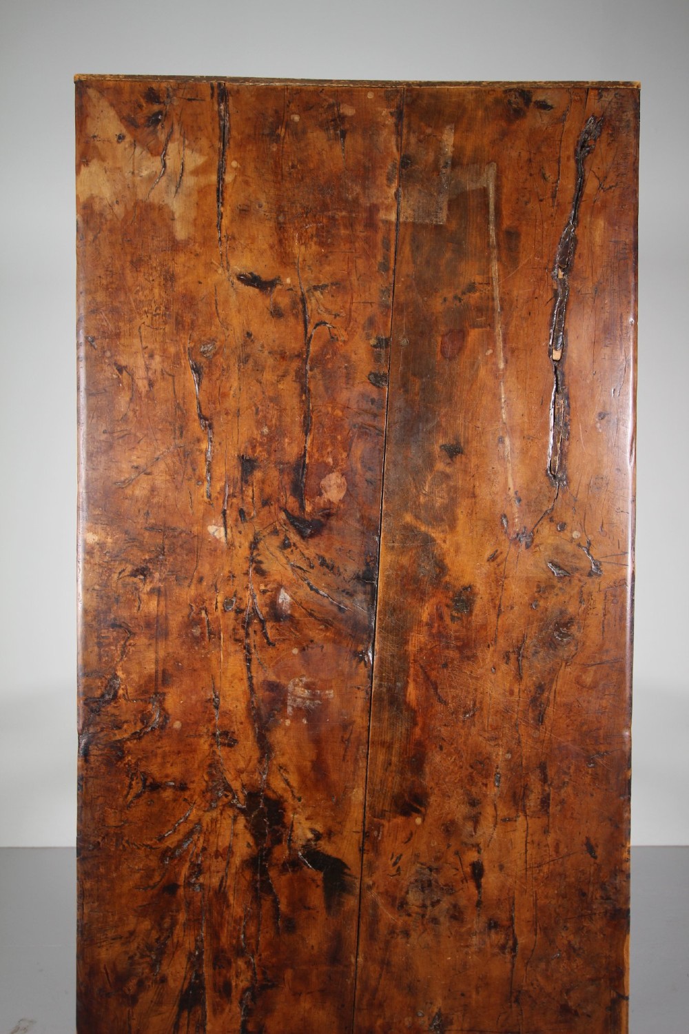 An 18th-century rustic fruitwood dining table featuring a solid plank top and straight square legs joined by a low stretcher base. View VII