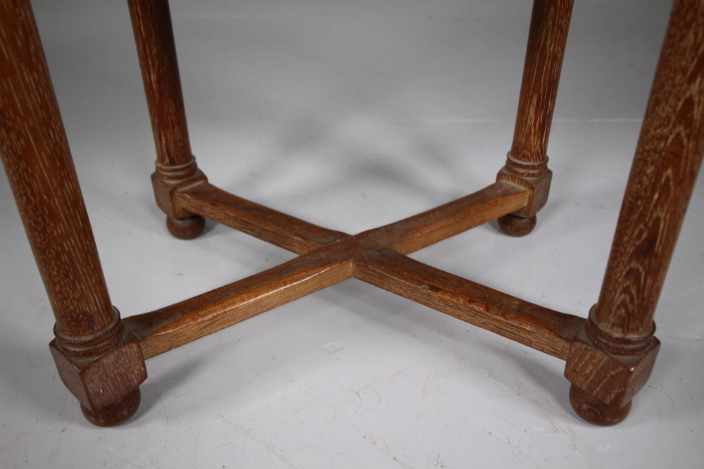An antique oval oak stool featuring a woven natural rush seat, cylindrical turned legs, and a crossover X-frame stretcher at the base. View IV