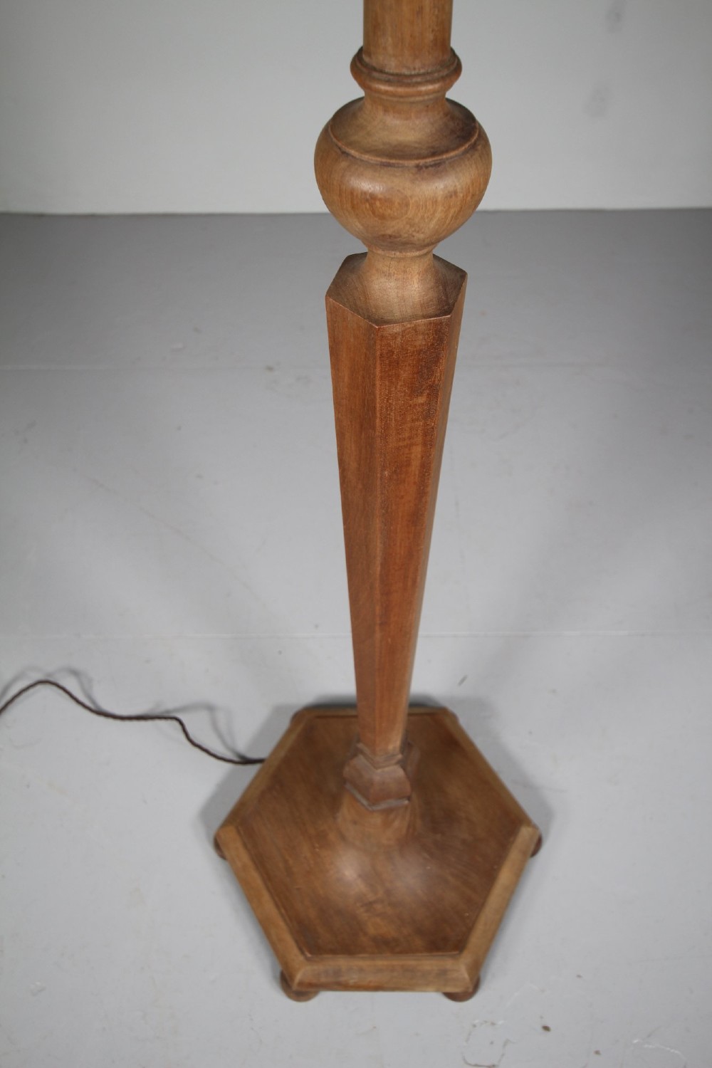 A 1930s turned walnut floor lamp featuring a tapered column resting on a moulded hexagonal base with bun feet. View II