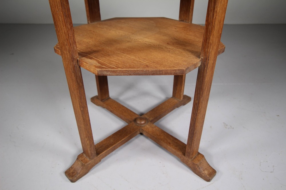 A circular antique oak side table featuring an intermediate lower shelf and an X-frame base stretcher. View II