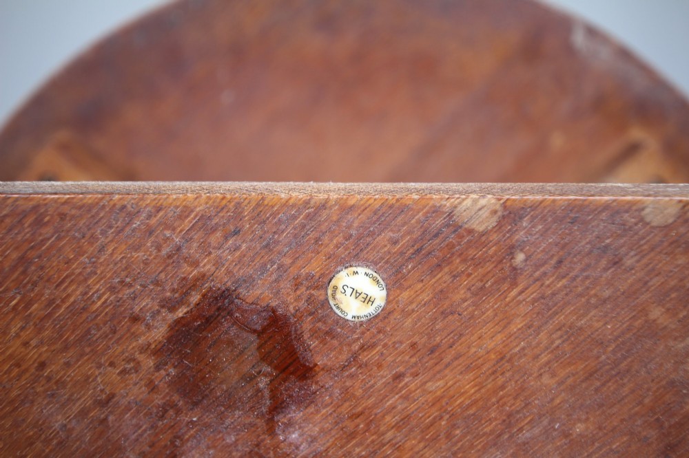 A circular antique oak side table featuring an intermediate lower shelf and an X-frame base stretcher. View IV