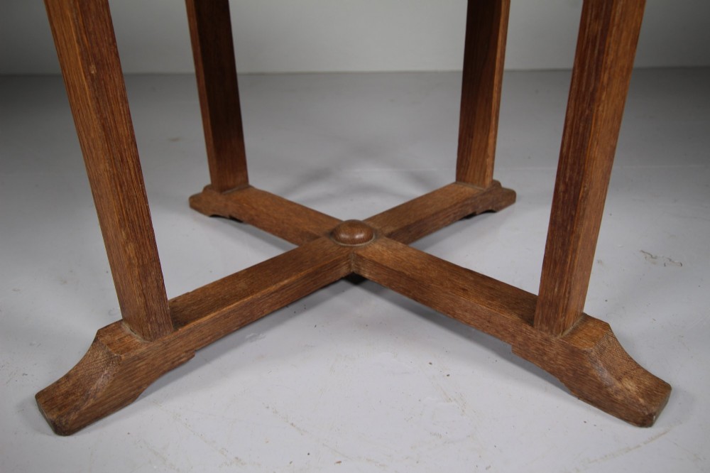 A circular antique oak side table featuring an intermediate lower shelf and an X-frame base stretcher. View VII