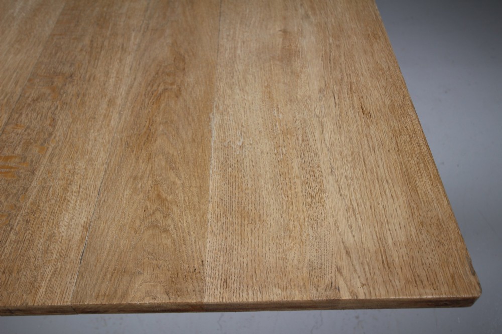 A 1930s solid oak refectory dining table featuring a rectangular top set over double column trestle ends and a low central stretcher. View IV
