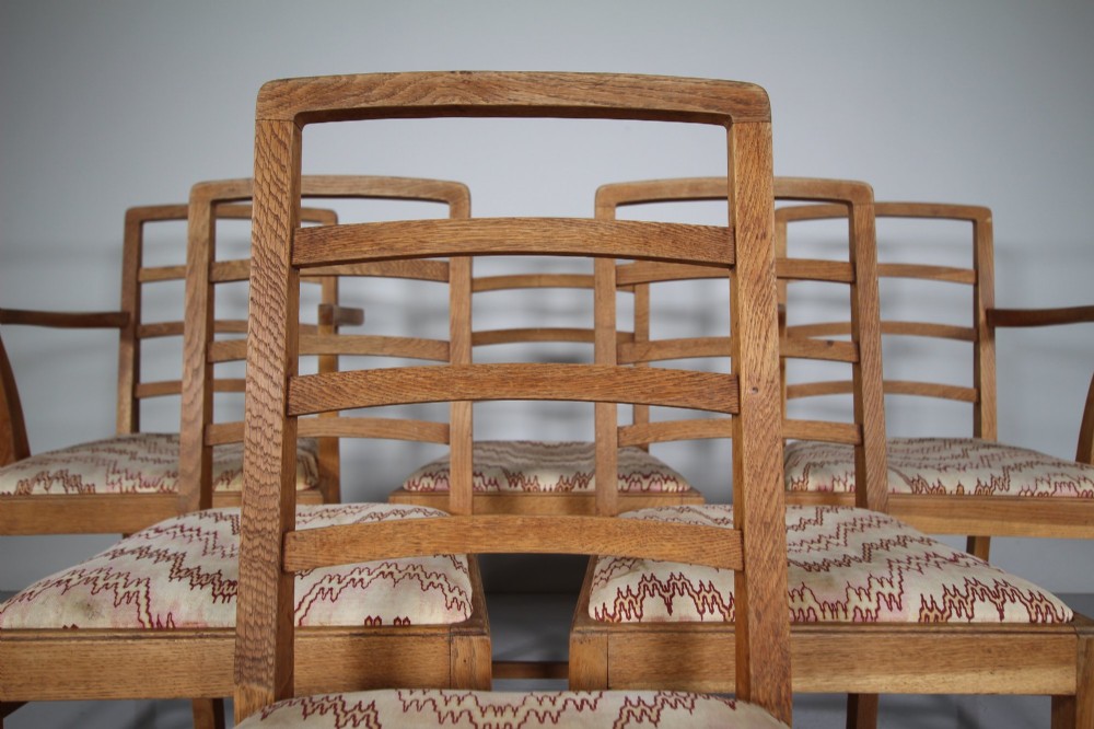 A set of six 1920s oak dining chairs including two armchairs, featuring structured horizontal ladder backs and patterned fabric upholstered seats. View IV