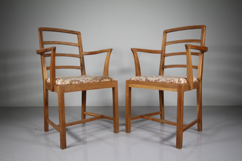 A set of six 1920s oak dining chairs including two armchairs, featuring structured horizontal ladder backs and patterned fabric upholstered seats. View VII