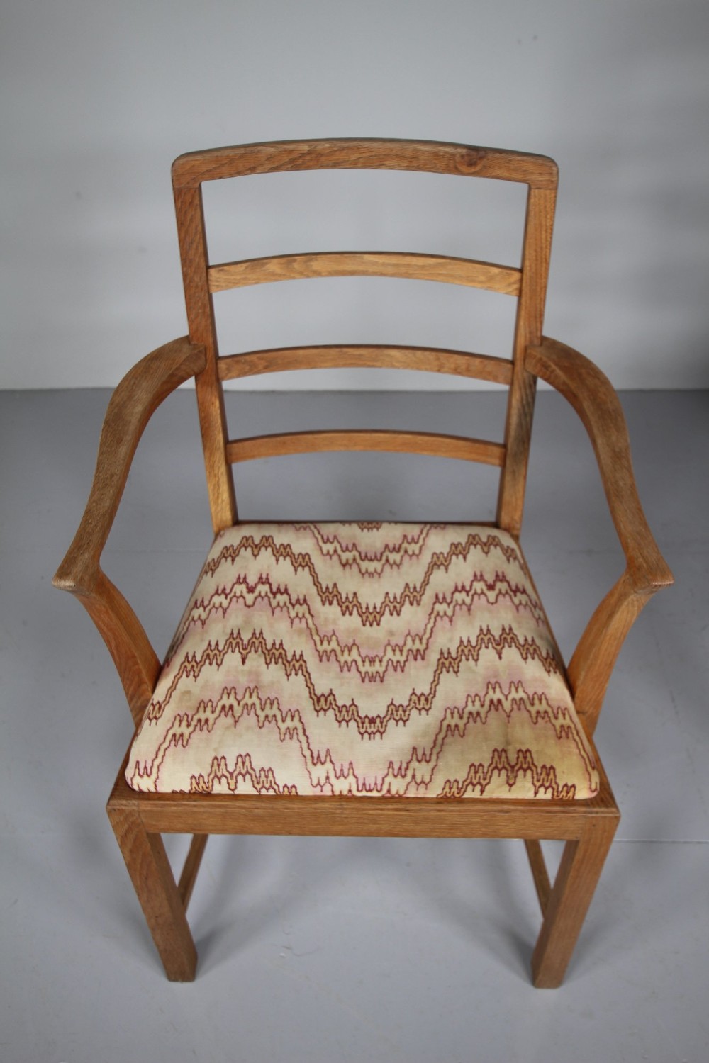 A set of six 1920s oak dining chairs including two armchairs, featuring structured horizontal ladder backs and patterned fabric upholstered seats. View VIII