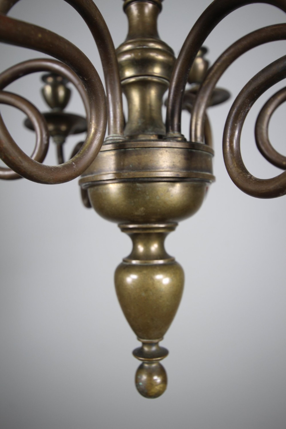 A 19th-century cast bronze six-arm chandelier featuring a central turned baluster stem, scrolled branches, and candle sconces. View III