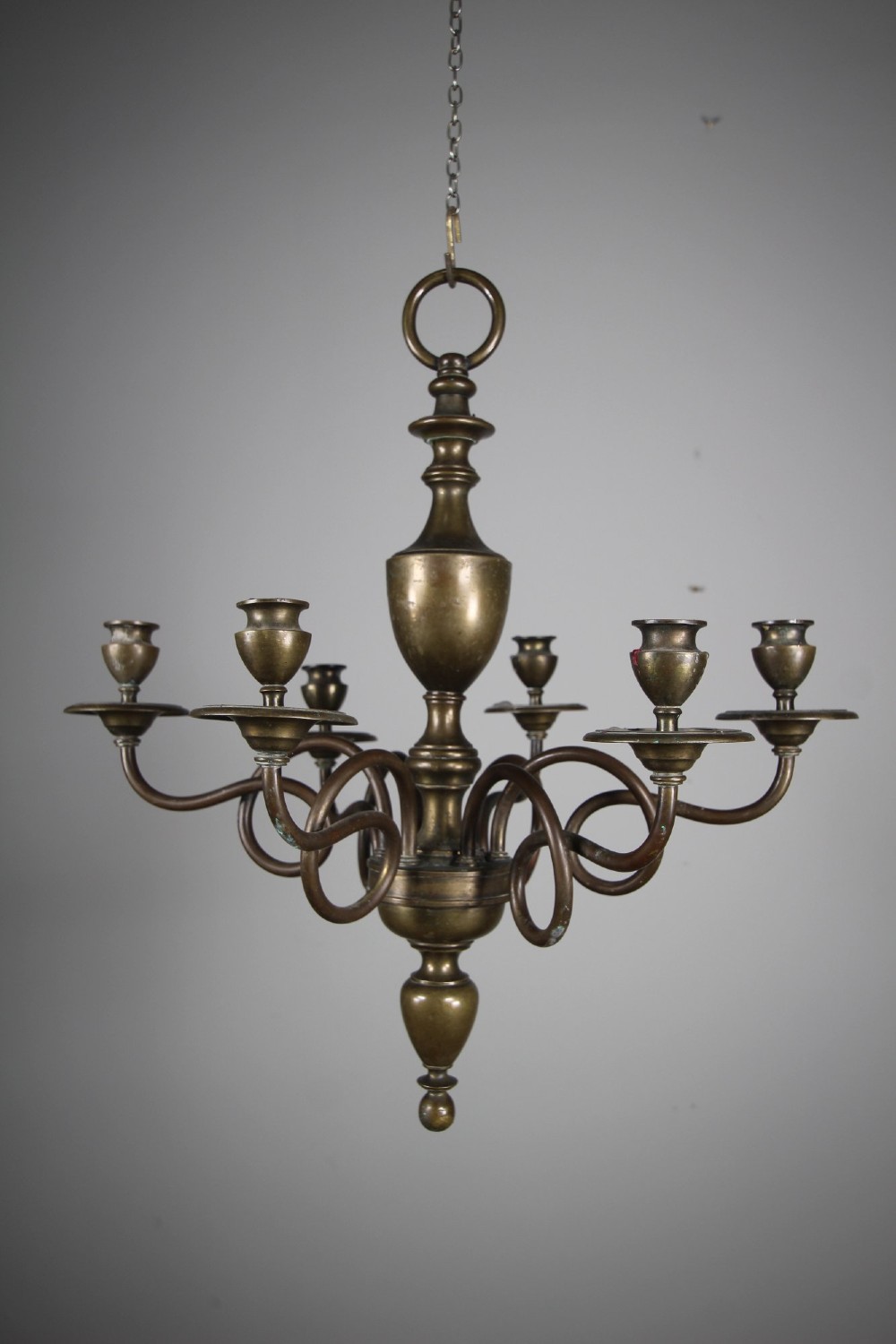 A 19th-century cast bronze six-arm chandelier featuring a central turned baluster stem, scrolled branches, and candle sconces. View VI