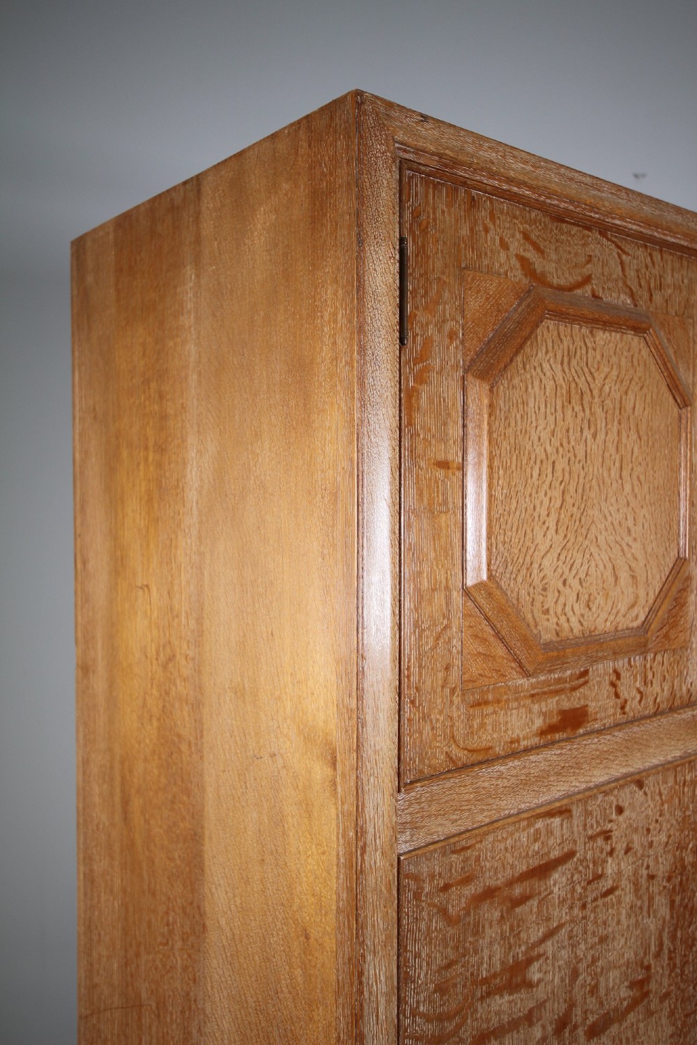 A tall light oak two-door wardrobe featuring octagonal upper panels, quarter-sawn wood grain, and small turned knobs on a plinth base. View VI