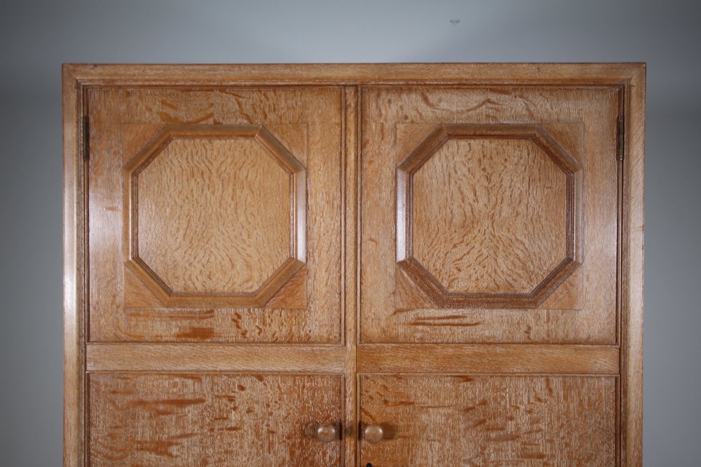A tall light oak two-door wardrobe featuring octagonal upper panels, quarter-sawn wood grain, and small turned knobs on a plinth base. View VII
