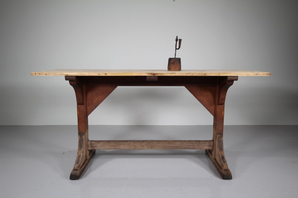 An antique 19th-century English tavern table featuring a scrubbed pine top resting on a red painted trestle base with a central stretcher. View IV