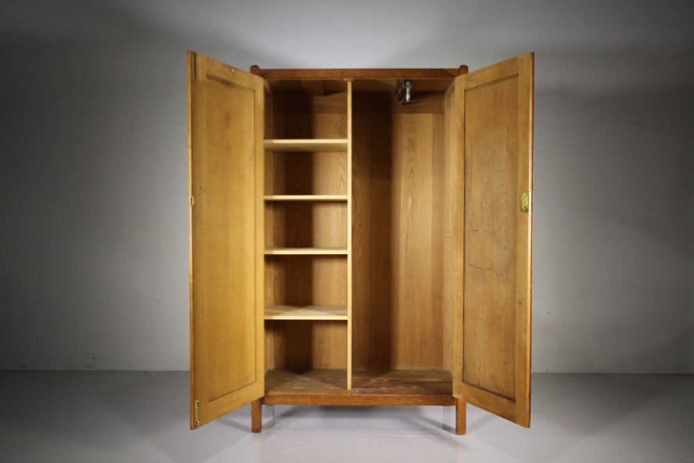 An Arts and Crafts solid oak double-door wardrobe featuring flat recessed timber panels, small round wooden door handles, and straight square feet. View V