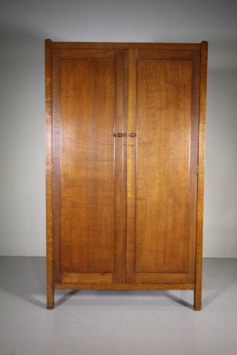 An Arts and Crafts solid oak double-door wardrobe featuring flat recessed timber panels, small round wooden door handles, and straight square feet. View III