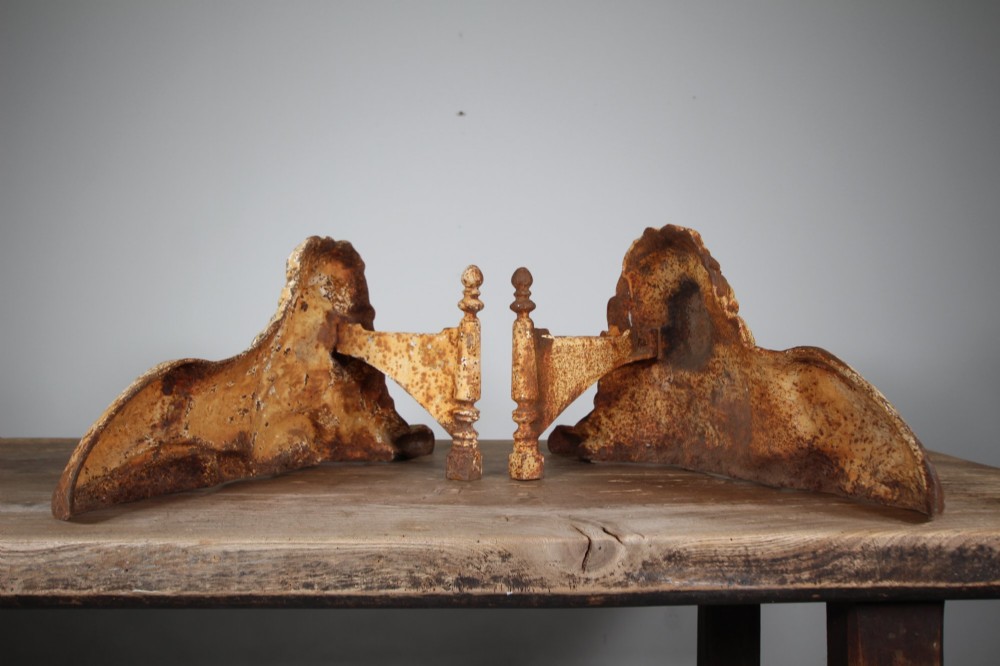 A pair of 19th-century cast iron recumbent lion boot scrapers featuring weathered cream paint and visible rust patination. View IV