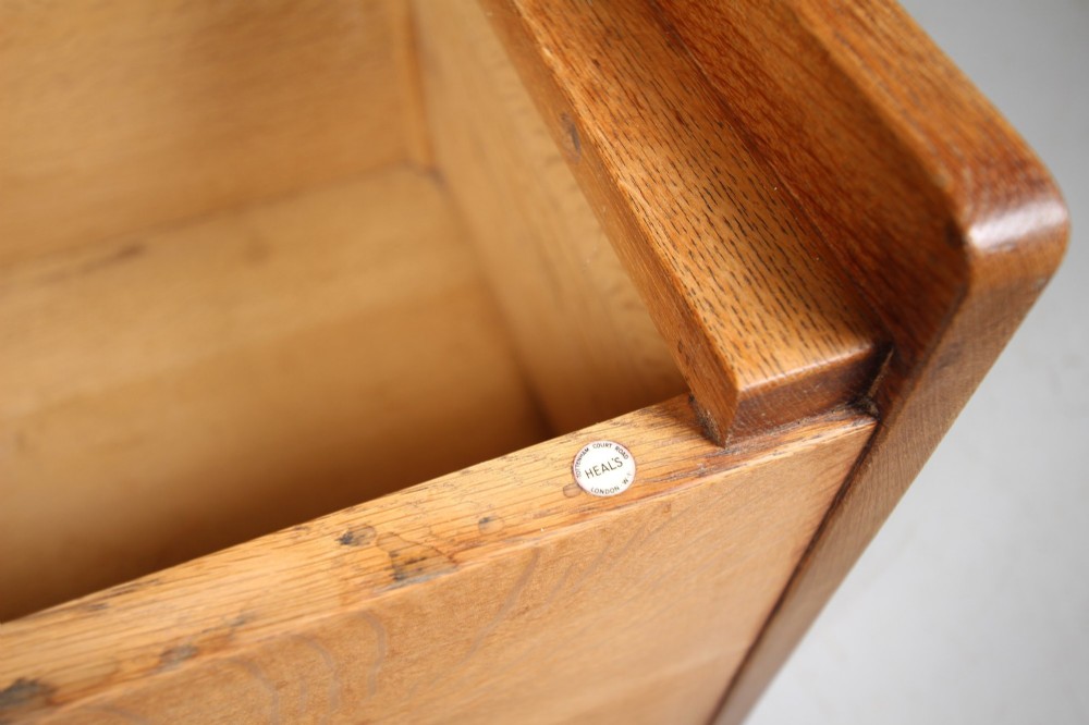A rectangular warm brown oak bedding box featuring side cut-out handles, a top lid, and four small metal castors. View V
