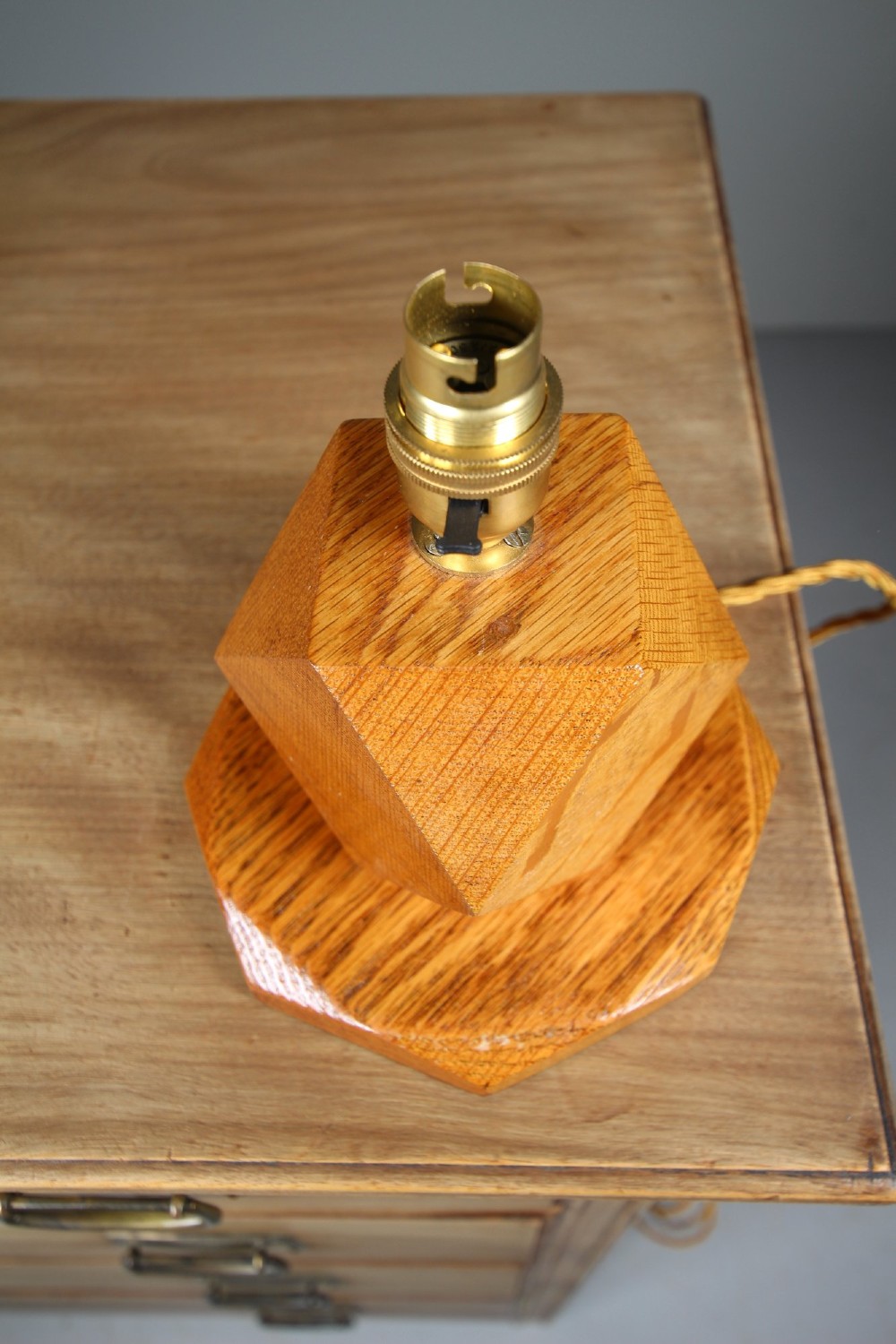 A 1920s geometric oak table lamp base featuring a faceted polyhedral stem set on an octagonal stepped wooden base with a brass socket. View IV